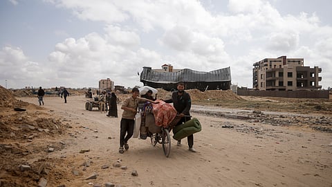 Palestinians carry their belonging after visiting their houses destroyed in the Israeli offensive on Khan Younis, Gaza Strip.