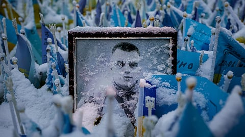Snowflakes cover the photograph of a fallen Ukrainian serviceman , in downtown Kyiv, Ukraine, Tuesday, March 12, 2024. 