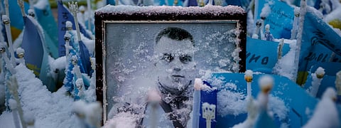 Snowflakes cover the photograph of a fallen Ukrainian serviceman , in downtown Kyiv, Ukraine, Tuesday, March 12, 2024. 