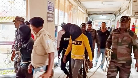Police personnel escort men accused for allegedly carrying out a brutal assault on a Spanish woman, to a district court in Dumka in Jharkhand.