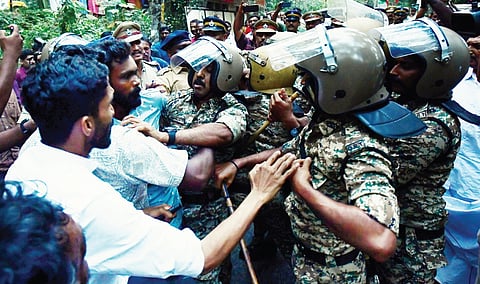 Quick response team personnel trying to remove agitated local residents who blocked the ambulance carrying the body of Indira, who was killed in a wild elephant attack, at Neriamangalam on Monday 