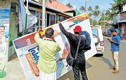 An anti- defacement squad under the Election Commission removing illegal hoarding put up on a bus stop near Anchuthengu on Friday