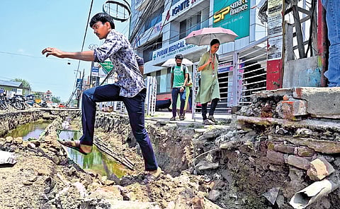 A pedestrian crosses a dug up road which is under renovation for Smart City project, at Attakulangara in Thiruvananthapuram |