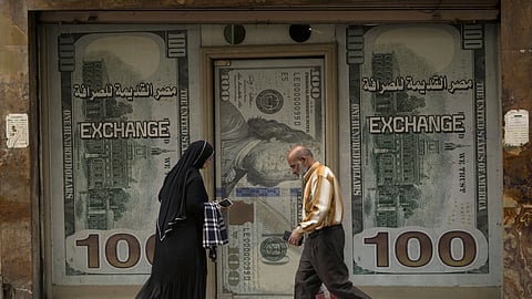 Egyptians walk past an exchange office in Cairo, Egypt, Wednesday, March 6, 2024.