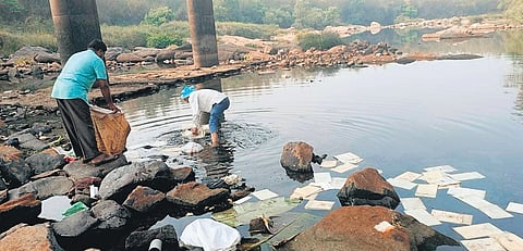Some members of the family remove trash that they had dumped earlier in the Cauvery river in Kushalnagar