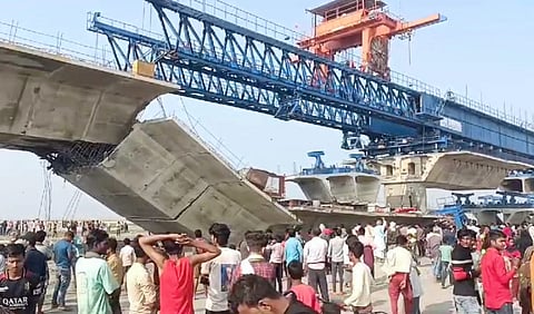 People gather after a part of an under-construction bridge over Kosi river collapsed, in Supaul, Friday, March 22, 2024.