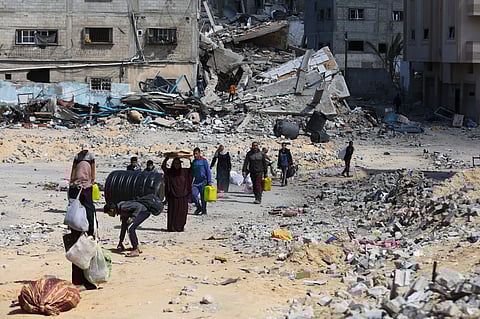 Palestinians walk through the destruction left by the Israeli offensive on Khan Younis, Gaza Strip.