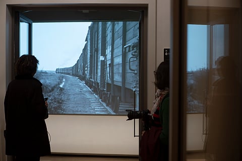 People look at historic footage of trains carrying Jews to Nazi concentration camps during a press preview of the new National Holocaust Museum in Amsterdam, Netherlands, Tuesday, March 5, 2024.