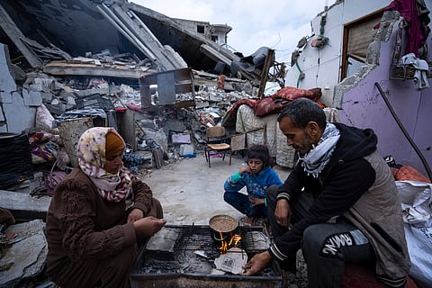 Members of the Al-Rabaya family break their fast during the Muslim holy month of Ramadan outside their destroyed home by the Israeli airstrikes in Rafah, Gaza Strip, Monday, March 18, 2024.