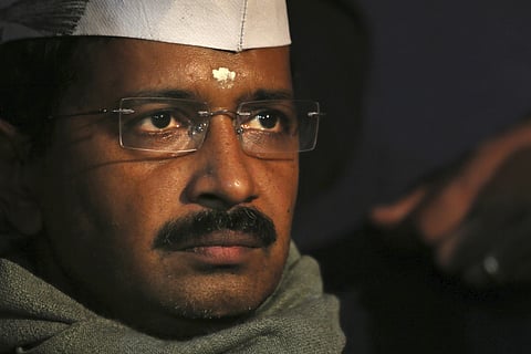 Aam Aadmi Party, or Common Man's Party, leader Arvind Kejriwal listens to a speaker during a public meeting in New Delhi, India, Dec. 27, 2013. 