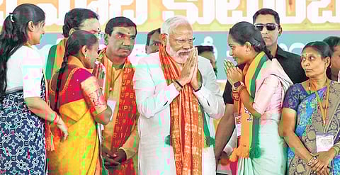 Prime Minister Narendra Modi greets women BJP activists in Jagtial on Monday