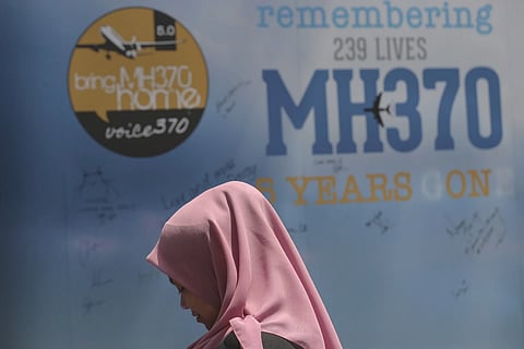 A girl stands in front of a condolence message board during a Day of Remembrance r MH370 event in Kuala Lumpur, Malaysia, on March 3, 2019.