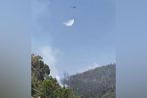 In an attempt to douse off a fire that was going out of control in the last four days, An IAF helicopter has sprayed water.