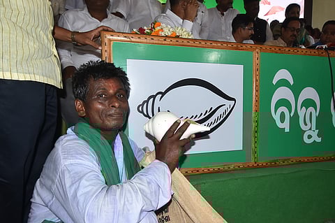 A man holds a conch to blow during a programme at BJD party office in Bhubaneswar. 