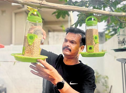 Anantula Ramesh refills the bird feeder in the backyard of his house in Karimnagar