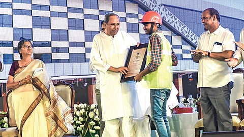 Chief Minister Naveen Patnaik handing over certificate of appreciation to a worker involved in construction of the inter-state bus terminal at Baramunda in Bhubaneswar on Friday 
