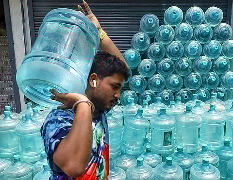 A man carries a drinking water can after buying it from a store amid the ongoing water crisis in Karnataka, in Bengaluru