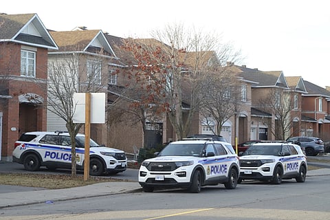Police vehicles parked at the scene where six people were found dead, Thursday, March 7, 2024.