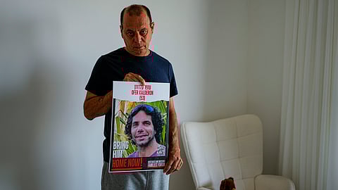 Nissan Kalderon poses with a photo of his only brother, Ofer, a hostage held in the Gaza Strip by the Hamas militant group, in Ramat Gan, Israel, Wednesday, March 13, 2024.