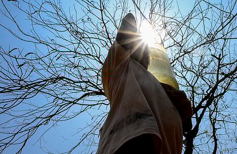 Girls cover their heads with a piece of cloth to protect themselves from scorching heat on a hot summer day