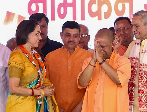 Uttar Pradesh Chief Minister Yogi Adityanath with BJP candidate Hema Malini during a public meeting on filing of nomination papers by her ahead of the Lok Sabha polls, in Mathura, Thursday, April 4, 2024.