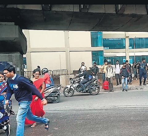 Students cross the Bengaluru-Mysuru National Highway near the Challaghatta Metro station