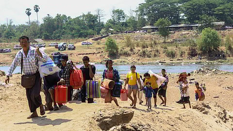 People cross the Moei river as they flee Myawaddy township in Myanmar to Thailand's Mae Sot town in Thailand's Tak province, Saturday, April 20, 2024. 