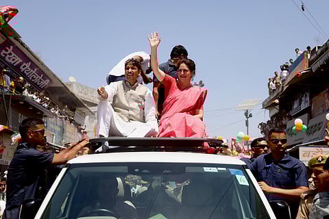 Priyanka Gandhi Vadra waves at supporters during a roadshow ahead of Lok Sabha elections, in Saharanpur
