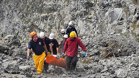 In this photo released by the Hualien Fire Department, firefighters and quarry workers evacuate a body from the Ho Ren Quarry a day after a powerful earthquake struck in Hualien County, eastern Taiwan.