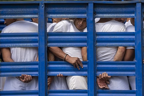 Men detained under a state of emergency are transported to a detention center in a cargo truck, in Soyapango, El Salvador, Friday, Oct. 7, 2022. 