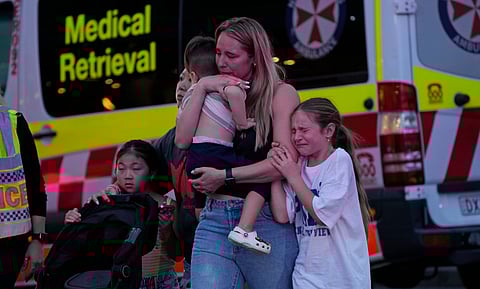 People are led out from the Westfield Shopping Centre where multiple people were stabbed in Sydney, Saturday, April 13, 2024.