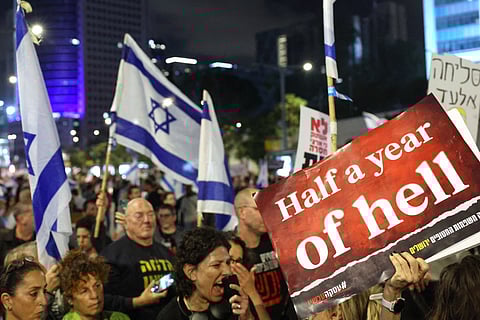 Relatives and supporters of Israeli hostages held in Gaza since the October 7 attacks by Hamas militants hold placards and wave Israeli flags during a demonstration in front of the Defence Ministry in the Israeli coastal city of Tel Aviv, on April 6, 2024