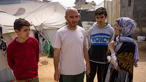 Heba al-Haddad, right, and her family displaced from Gaza City, stand in a makeshift tent camp in Rafah, southern Gaza, Friday, March 29, 2024.