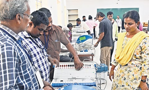 Adding candidates’ names and party symbols to EVMs at Nandanam college 