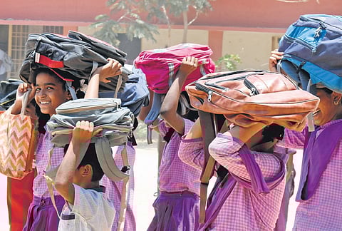 Students protect themselves with bags as they return home from school in Tirupati. Only one mandal in Annamayya experienced severe heatwave on Monday | Madhav K