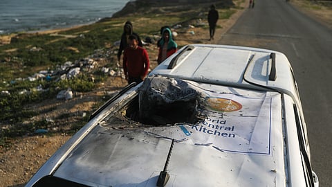 Palestinians inspect a vehicle with the logo of the World Central Kitchen wrecked by an Israeli airstrike in Deir al Balah, Gaza Strip.