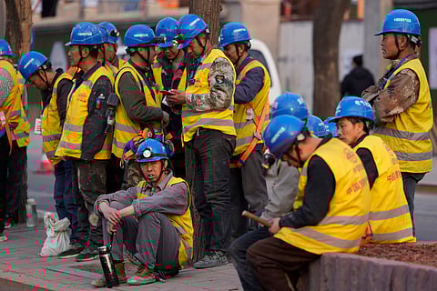 Chinese workers waiting at a construction site. China's economy expanded at a faster than expected pace in the first three months of the year, helped by policies aimed at stimulating growth and stronger demand, the government said Tuesday, April 16.