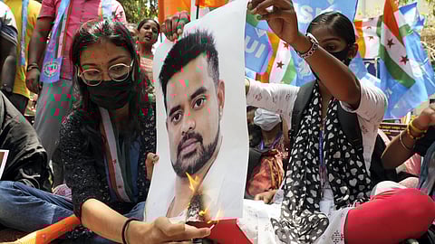 Protestors burn a poster of JD(S) MP Prajwal Revanna during a protest against his involvement in the sexual abuse case.