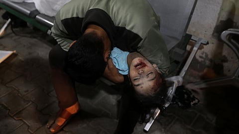 A Palestinian youth mourns his relative killed in the Israeli bombardment of the Gaza Strip, at the morgue of the Kuwaiti Hospital in Rafah refugee camp, southern Gaza Strip, early Saturday, April 20, 2024.