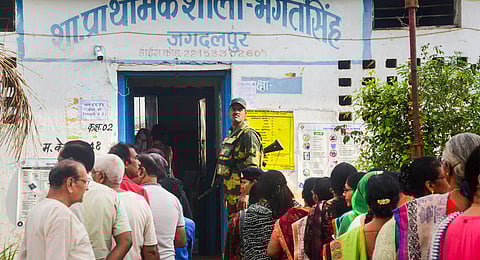 Voters wait in queues at a polling station to cast their votes for the first phase of Lok Sabha elections, in Bastar district, Friday, April 19, 2024.