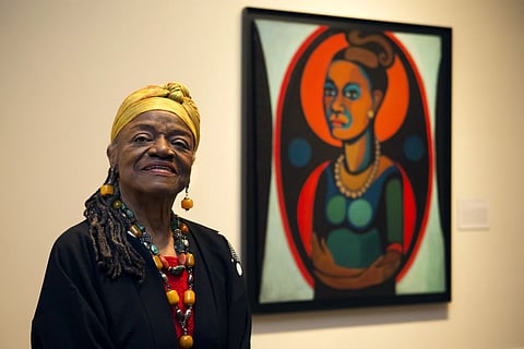Artist Faith Ringgold poses for a portrait in front of a painted self-portrait during a press preview of her exhibition, "American People, Black Light: Faith Ringgold's Paintings of the 1960's" at the National Museum of Women in the Arts in Washington, June 19, 2013.