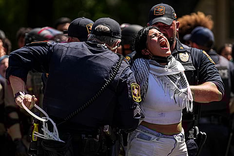 A pro-Palestinian protester yells "Free Palestine" as she is handcuffed by University of Texas at Austin police on the campus in Austin, Texas.