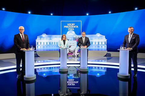 Slovakia's National Council speaker and presidential candidate Peter Pellegrini (R) and Slovakia's former foreign minister and presidential candidate Ivan Korcok (L) pose with presenters before the second round of the presidential elections.