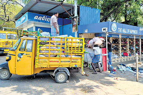 Stack of donated clothes getting loaded by workers on auto rickshaws 