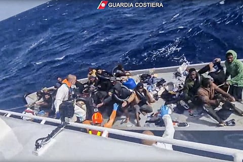 In this image taken from a video released by the Italian Coast Guard on Thursday, April 11, 2024, a boat with migrants is approached by a rescue operation off the island of Lampedusa in the Mediterranean Sea.