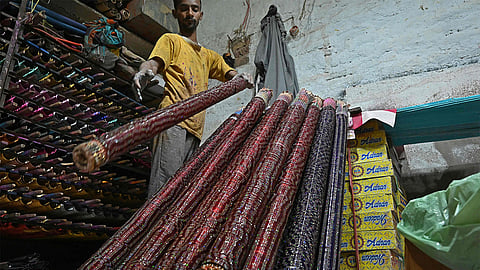 In this picture taken on March 31, 2024, a customer looks at bangles displayed in a shop in Hyderabad. 
