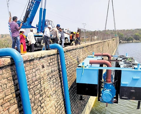 Officials install a pontoon affixed with two 150HP pumps at Himayatsagar