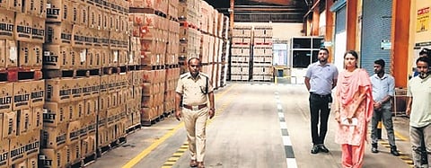 Excise department officials seen along with the liquor that was confiscated from United Breweries in Nanjangud
