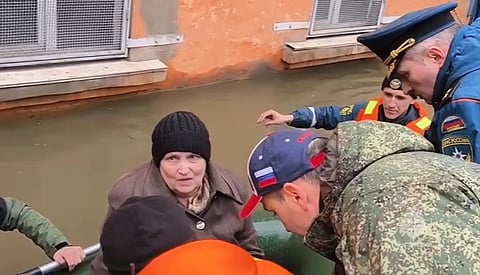 Russia’s Emergency Situations Minister Alexander Kurenkov, right speaks to a woman as emergency workers evacuate local residents with their pets after part of a dam burst causing flooding in Orsk, Russia.