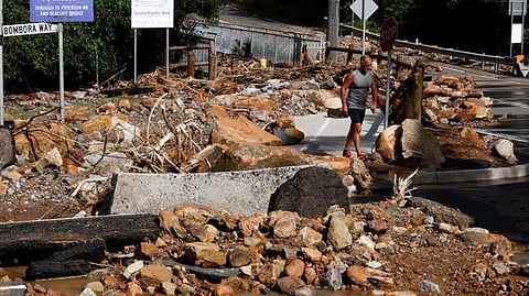 A resident walks past fallen rocks in Wollongong after heavy rain caused flooding in eastern Australia 